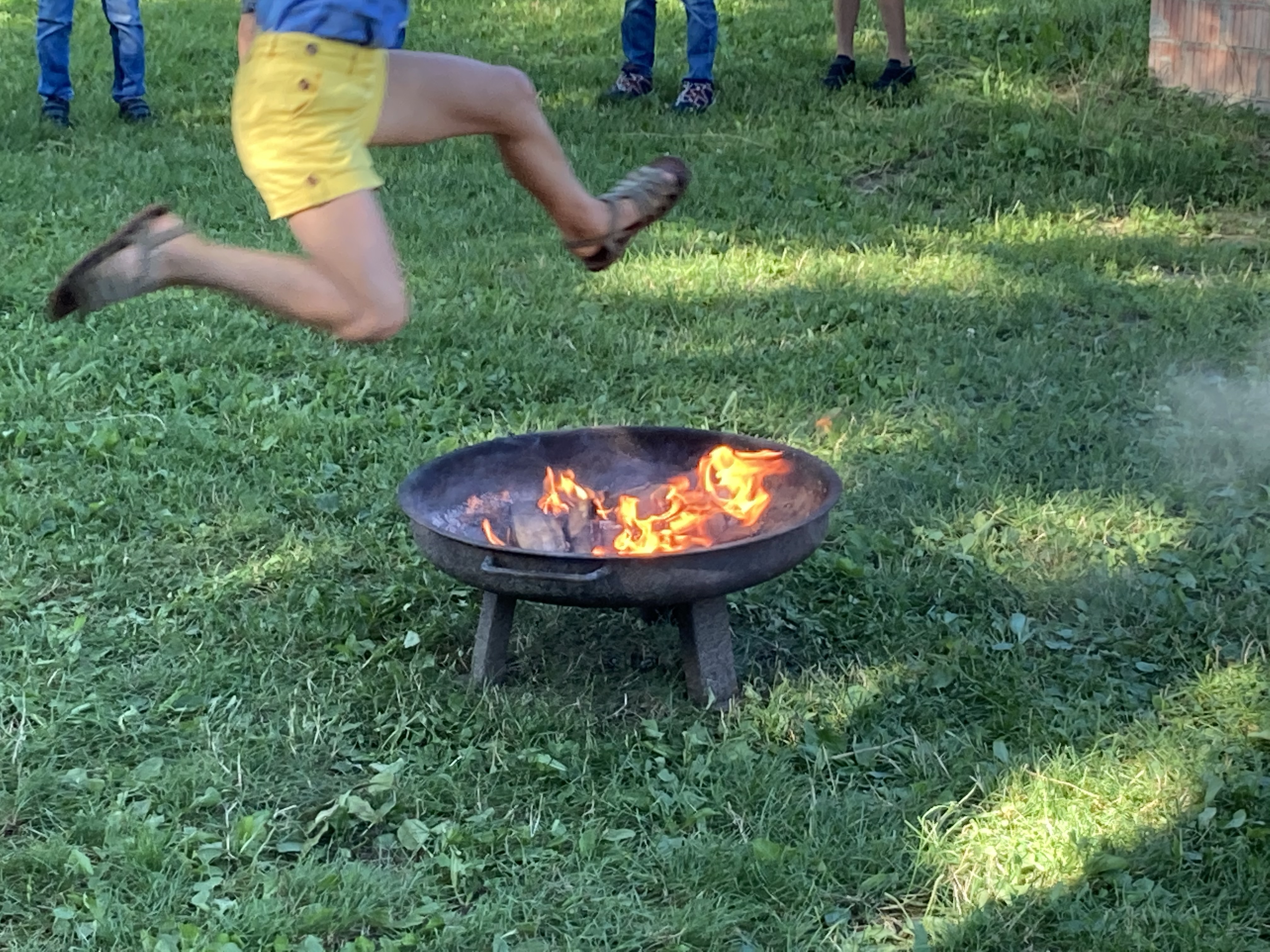 Kind springt über das Johannifeuer